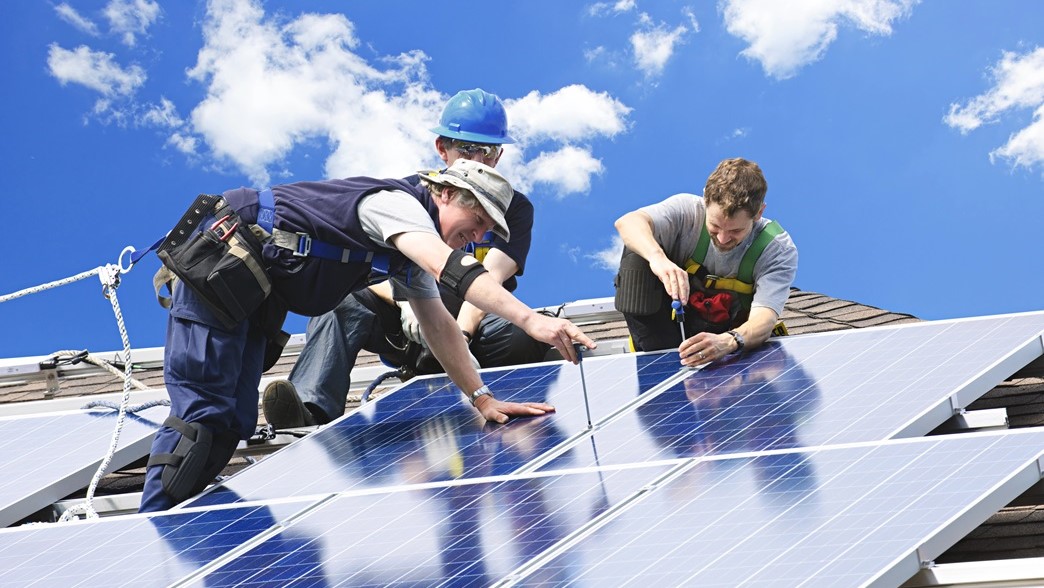 Männer auf Dach bringen Solaranlage an